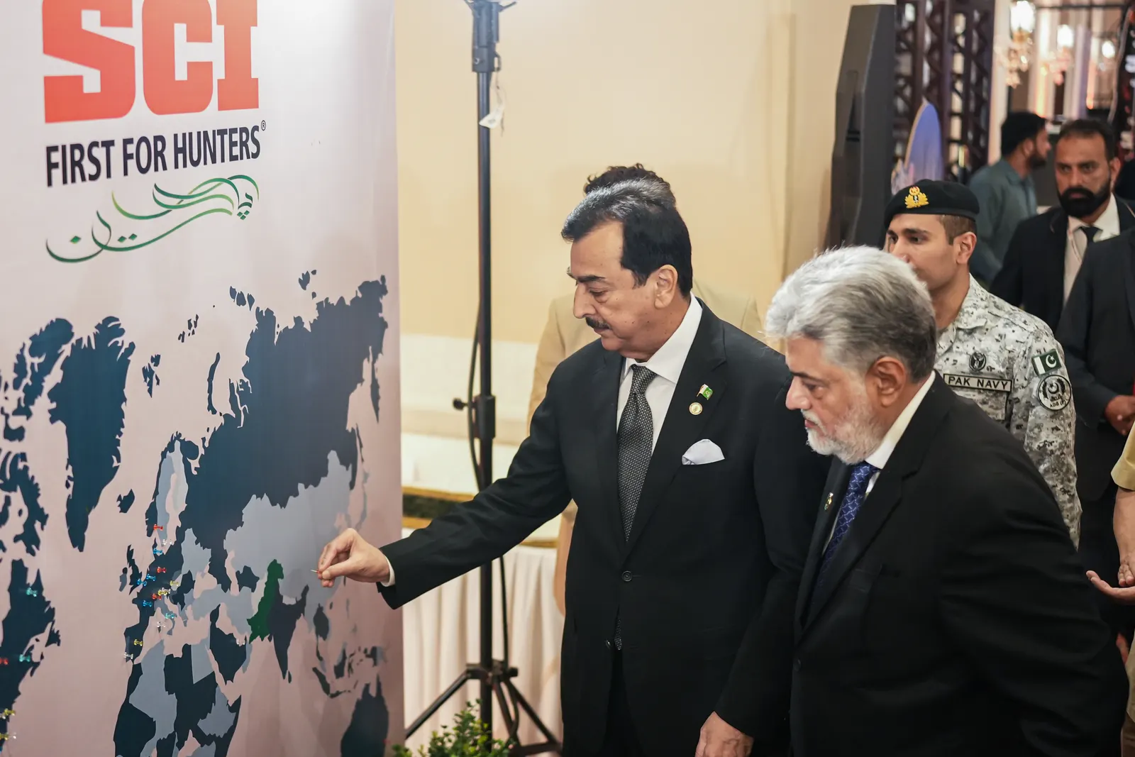 Acting President Syed Yusuf Raza Gilani and Syed Sumsam Bukhari at a world map of Safari Club International's chapters.