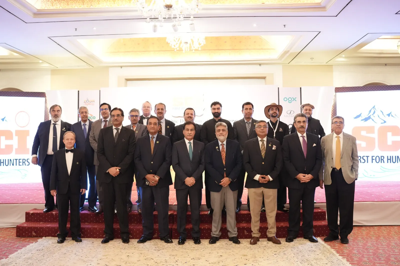 Chapter members, guests and visiting SCI delegates line up on stage for a group photograph.