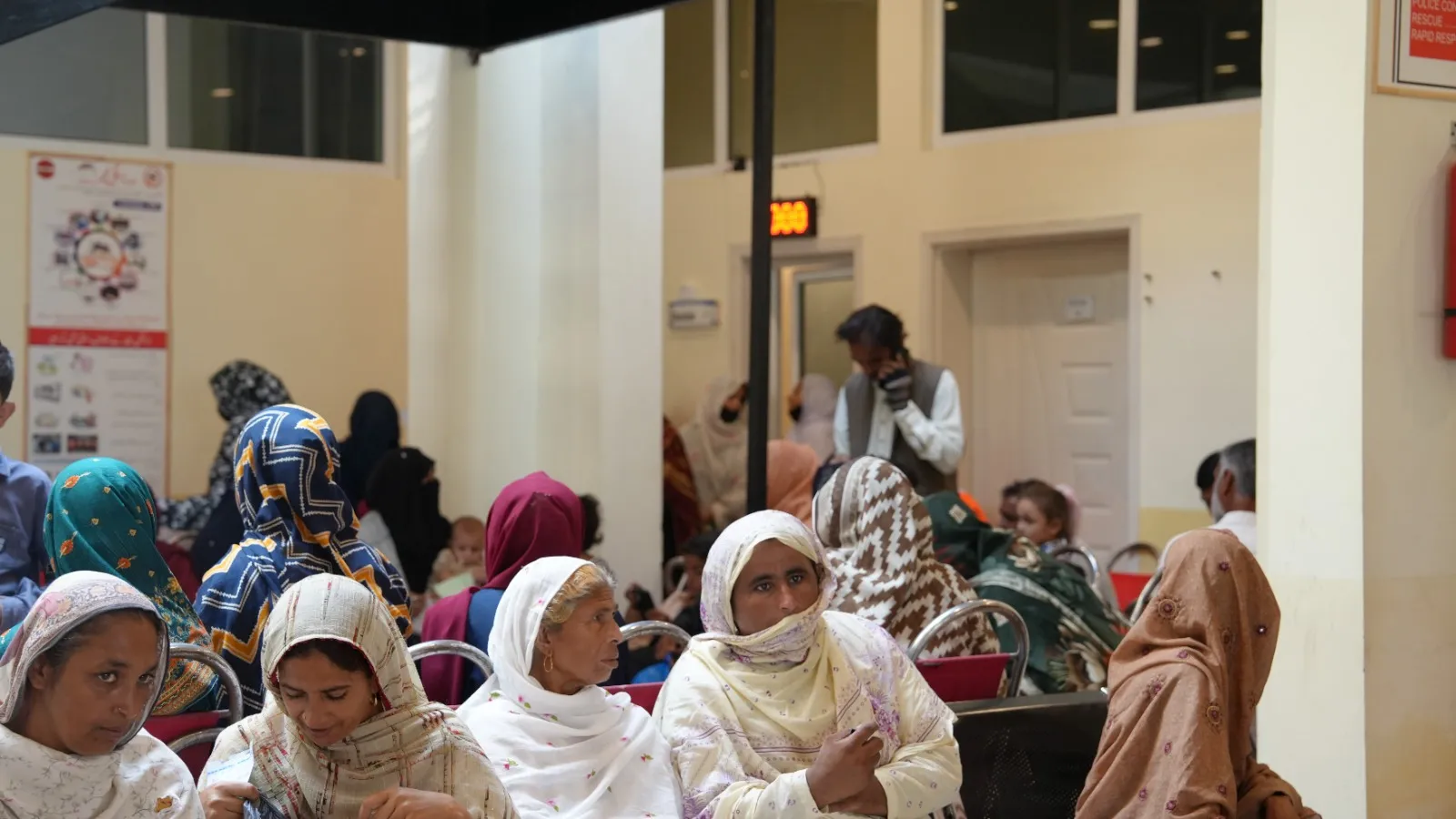 Women sit together in the camp’s main hall waiting to be seen.